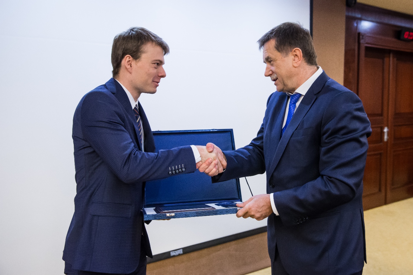 Сергей Хомяков (справа) поздравил заместителя заведующего отделом методологии управления активами ООО «НИИгазэкономика» Артема Курносенко с присуждением премии