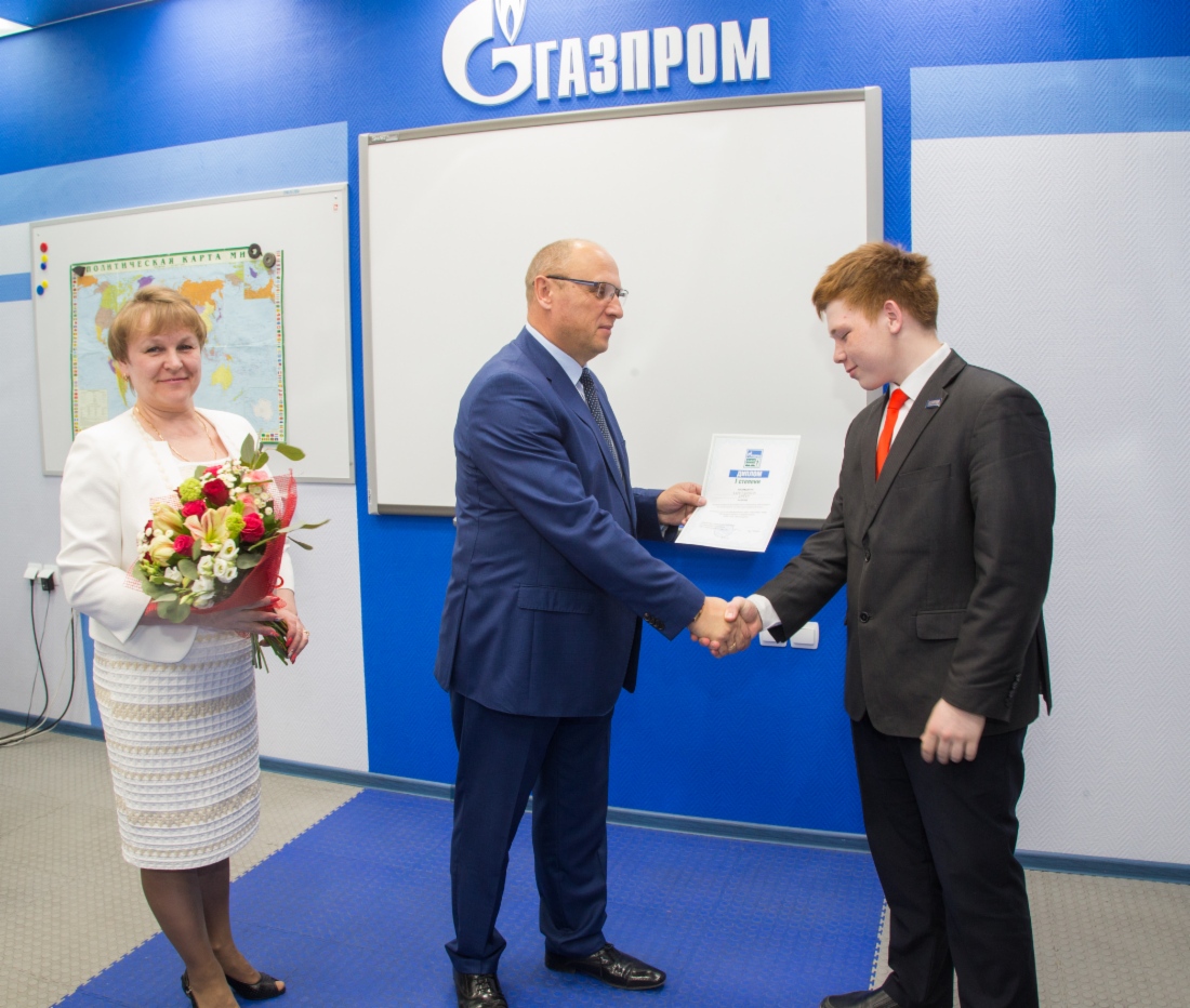 Начальник отдела кадров ООО «Газпром добыча Уренгой» Иван Забаев вручает диплом первой степени Артуру Заретдинову