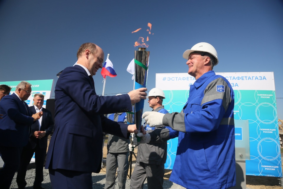 Заместитель генерального директора по экономике и финансам ООО «Газпром межрегионгаз» Николай Головкин принимает факел от сотрудника газораспределительной организации