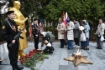 Жители поселка возлагают цветы к мемориалу с Вечным огнем