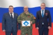 Герой России, советник генерального директора Дмитрий Воробьев и начальник Управления материально-технического снабжения и комплектации Общества Максим Карпов передают гуманитарный груз подполковнику Игорю Мусаеву