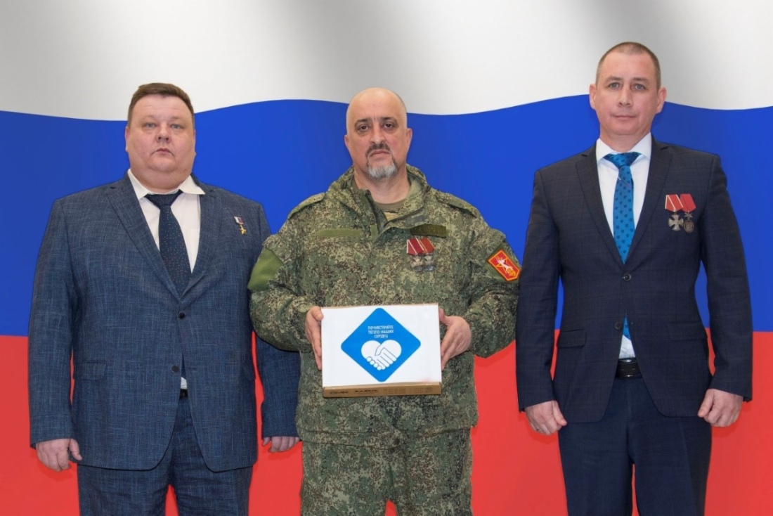 Герой России, советник генерального директора Дмитрий Воробьев и начальник Управления материально-технического снабжения и комплектации Общества Максим Карпов передают гуманитарный груз подполковнику Игорю Мусаеву