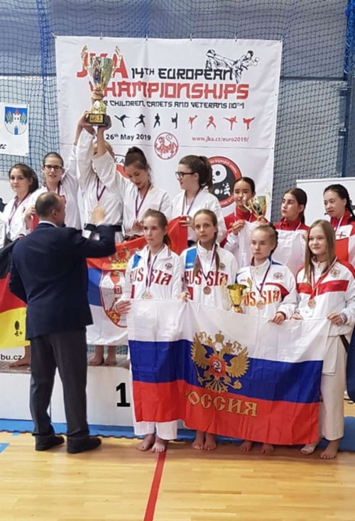Бронзовую награду в командном кумите получает Алина Анашкина (вторая слева)