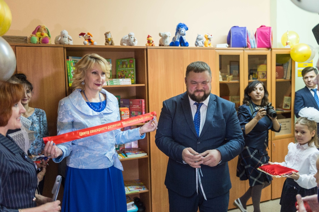 Марина Серикова демонстрирует ленту, торжественно разрезанную при открытии Центра