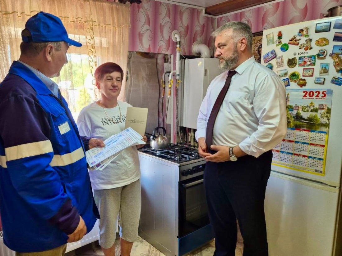 Газовик и глава округа Дмитрий Третьяков вручают заявителю памятку о безопасном использовании газа в быту
