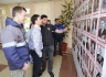Работники предприятия у стенда с фотографиями ветеранов